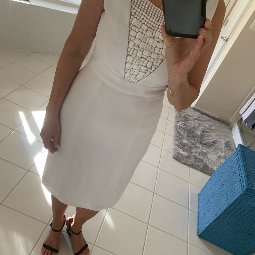 Elegant white dress with beads on front.